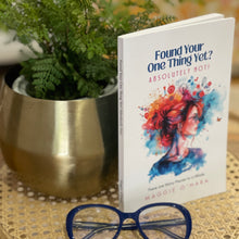 Load image into Gallery viewer, A paperback book titled 'Found Your One Thing Yet? Absolutely Not!' by Maggie O'Hara on a coffee table with blue reading glasses.
