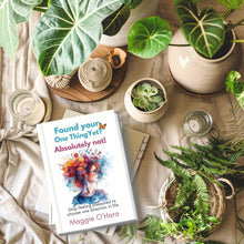 Load image into Gallery viewer, A mock up of a paperback book titled 'Found Your One Thing Yet? Absolutely Not!' by Maggie O'Hara. The book is on a table covered in calico and surrounded by plants.