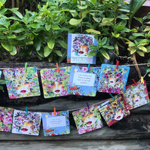 Load image into Gallery viewer, Faces of the Forest affirmation cards pegged on a string line in the garden, a tool for reflection, intention-setting, and self-discovery. 
